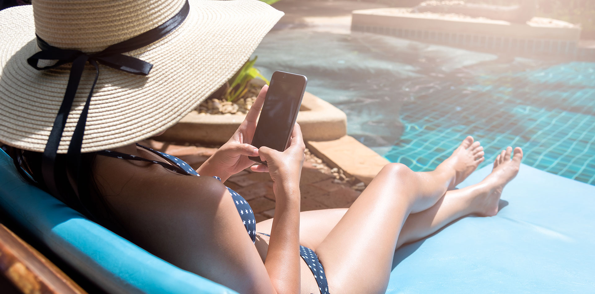 woman on her phone by the pool