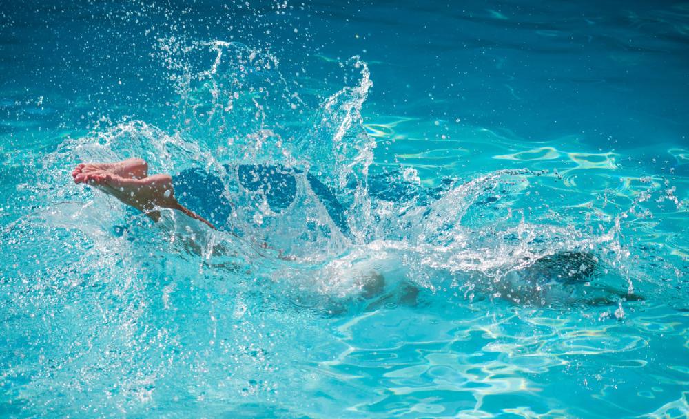 un bambino si tuffa in una piscina