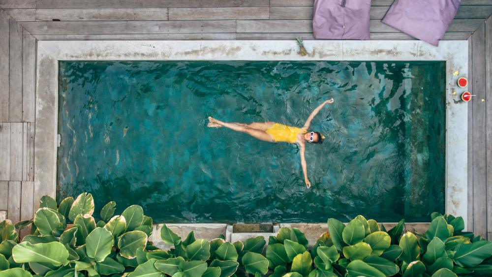 Dame lässt sich auf dem Rücken im Schwimmbad treiben