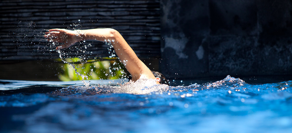 Mann, der in einem privaten Schwimmbad schwimmt