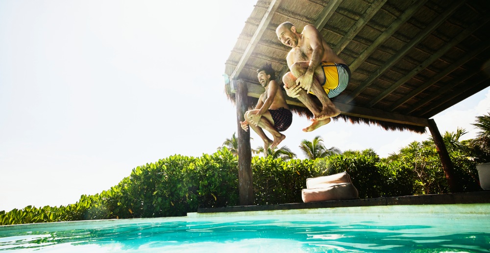 Zwei Männer springen in den Pool