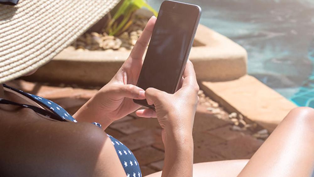 woman on phone by the pool